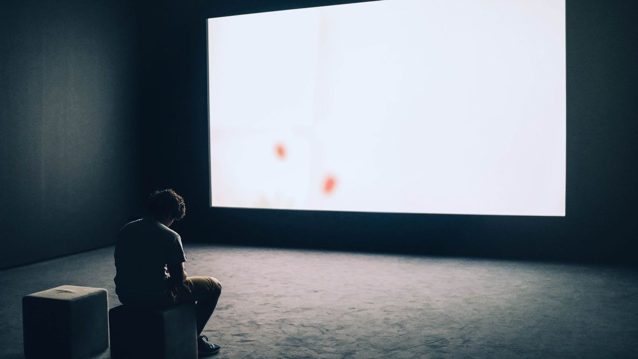 暗い部屋で、大きなスクリーンに映像が映っている